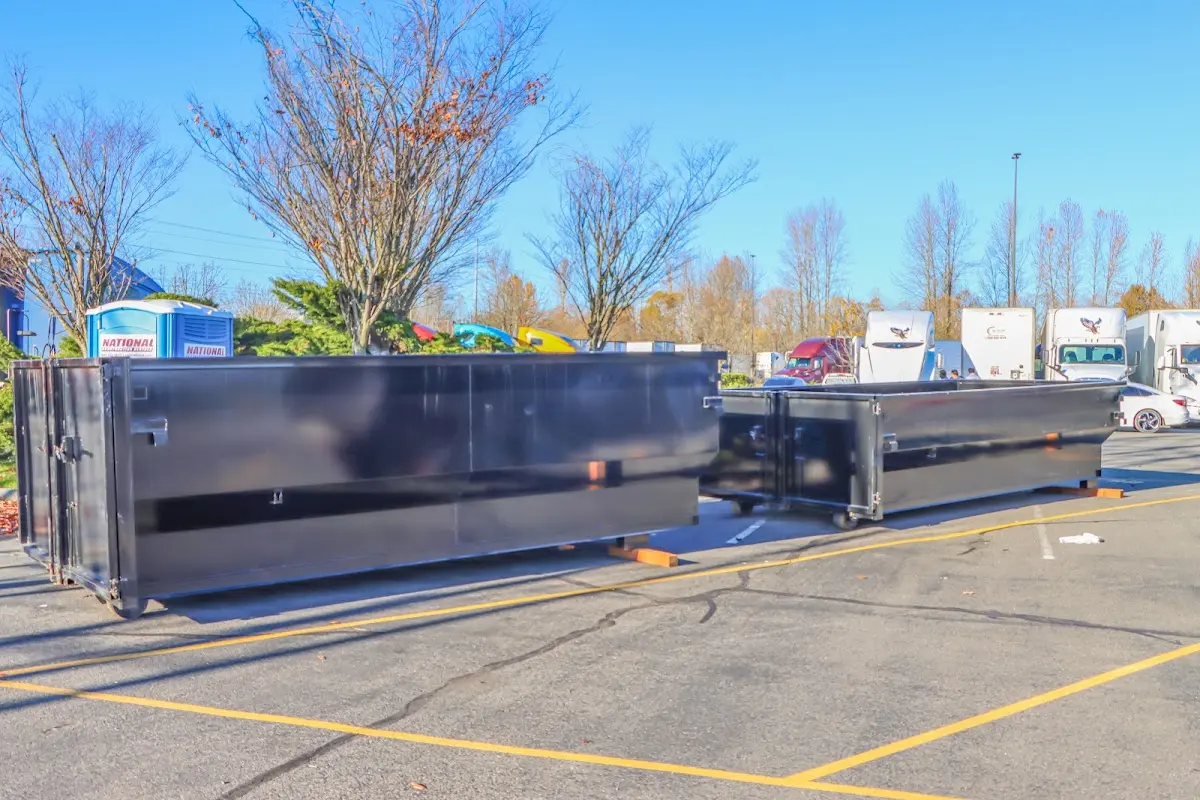 Professional dumpster rental service with roll-off container on residential driveway in West Frankfort